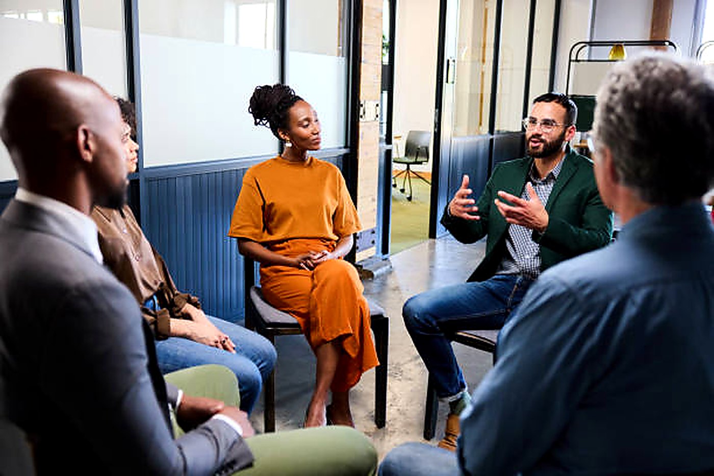 Practitioners and clients in conversation, seated in a circle